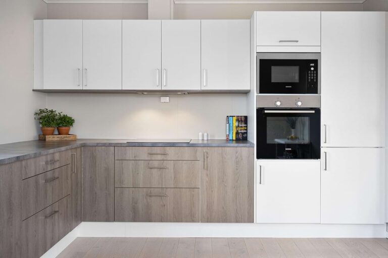 Modern kitchen with appliances and white cabinets.